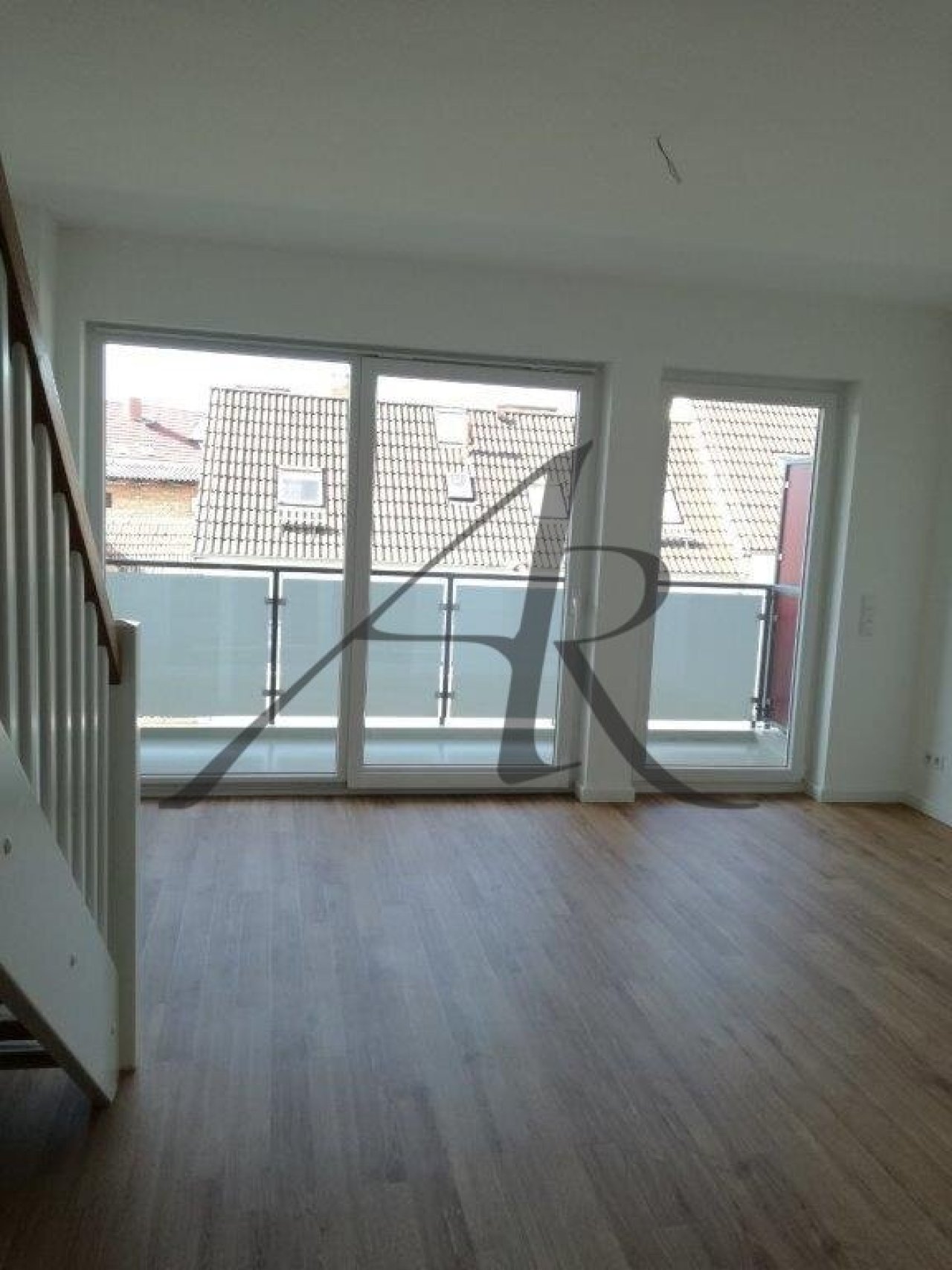 Wohnzimmer mit Balkon und Zugang zur oberen Ebene