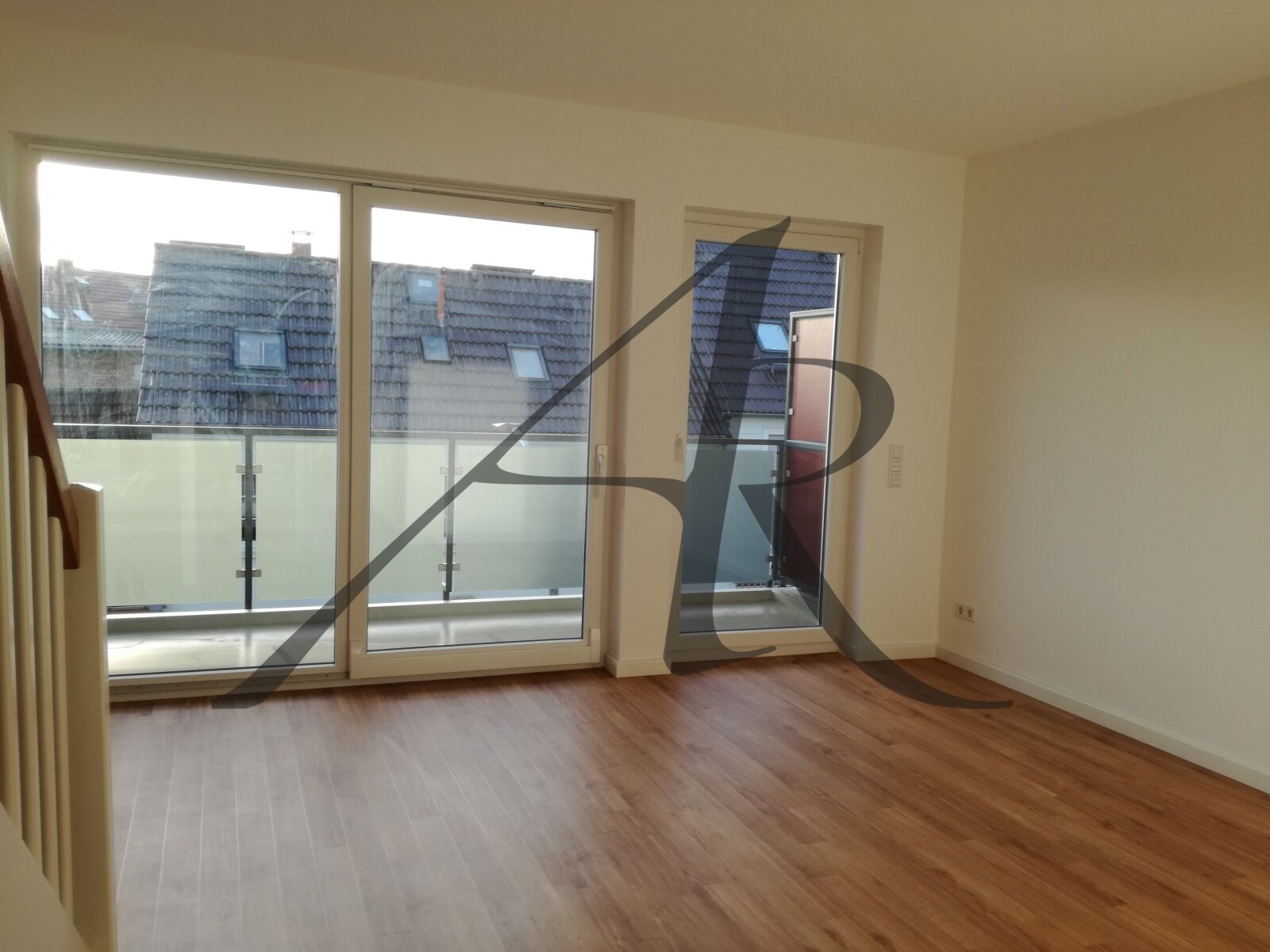 Wohnzimmer mit Balkon und Zugang zur oberen Ebene